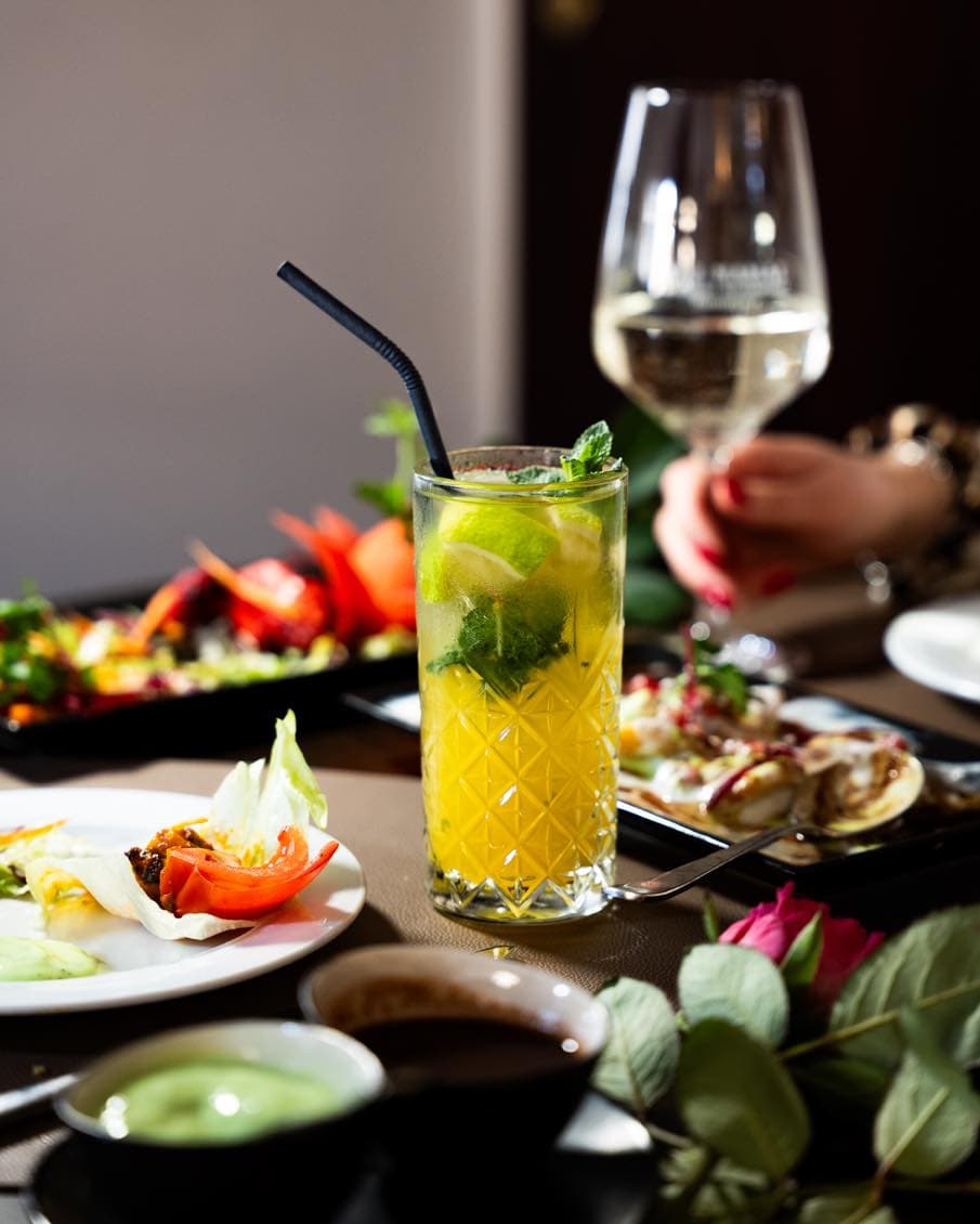 Frischer Mojito-Cocktail mit Limette und Minze auf gedecktem Tisch